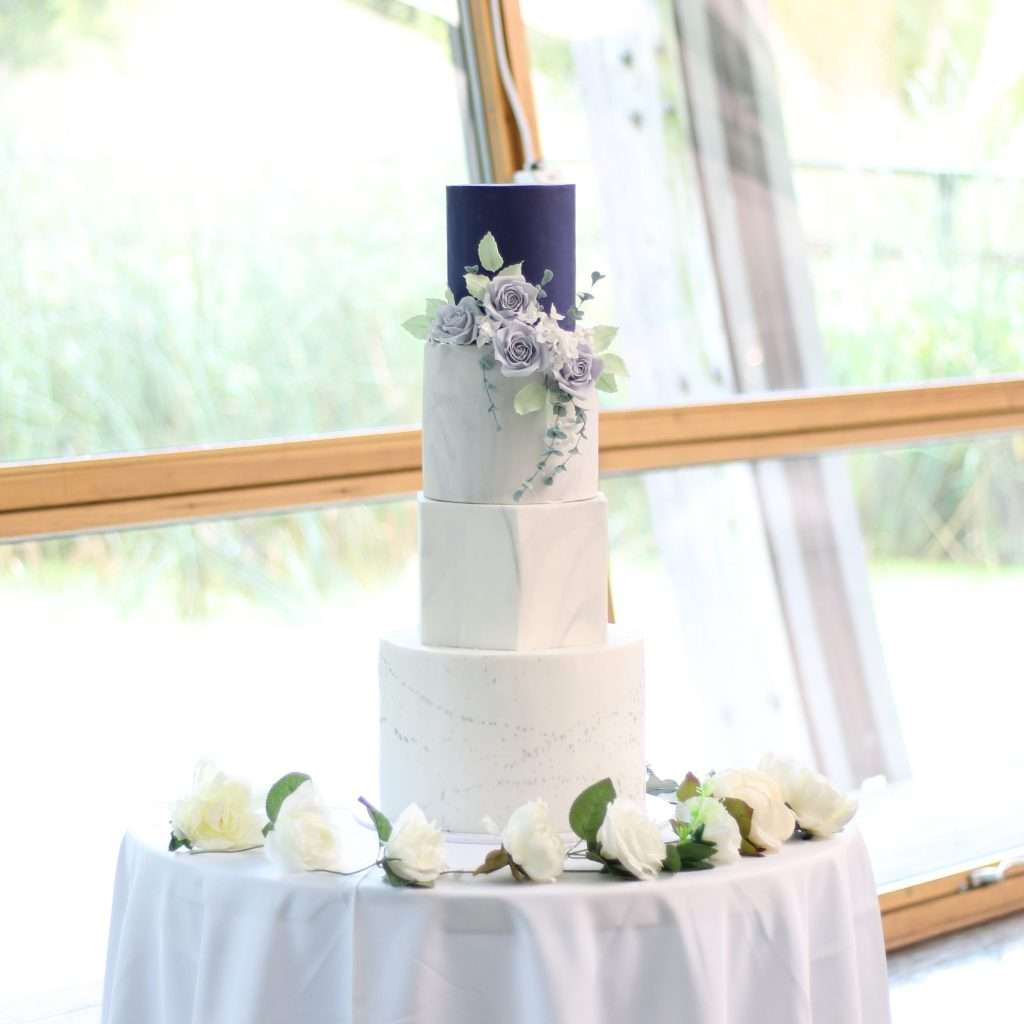 Blue, white, silver wedding cake with sugar flowers and hexagon tier at The Pavilion, Mile End