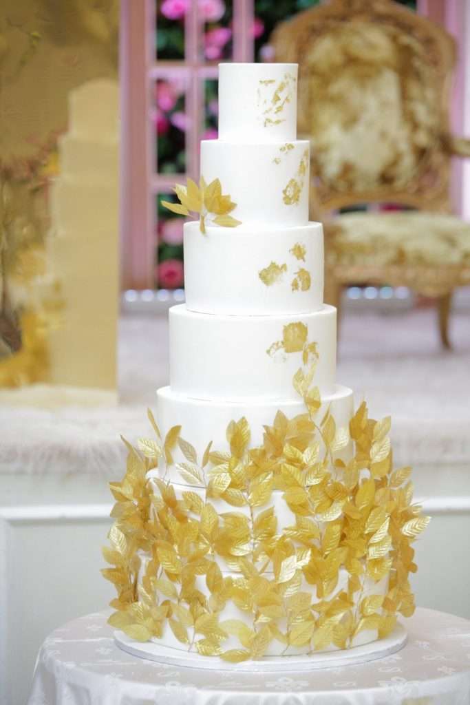 Seven tier white wedding cake with gold leaves at The Decorum, Wood Green